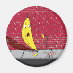 Banane, die auf einem Personen-Magneten gleitet