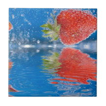 Frische Erdbeeren, die in Wasser spritzen Kacheln