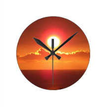 Glänzende orange Sonnenuntergang-Himmel-Wanduhr