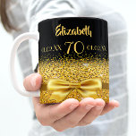 70. Geburtstag schwarzes Gold eleganter Name Klass Kaffeetasse<br><div class="desc">Elegant, klassisch, glamourös und feminin. Ein goldfarbenes Band und Bogen mit goldenem Glitzer und Funkeln, ein bisschen Bling und alltäglicher Luxus. Schwarzer Hintergrund. Das perfekte Geschenk für einen 70. Geburtstag! Vorlagen für einen Namen, 70 Jahre und Geburtsdatum und das Jubiläum. Goldene Buchstaben. Der Name ist mit einem modernen handgeschriebenen Stilskript...</div>