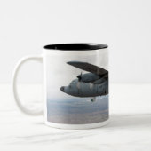 A C-130 Herkules steigt durch den Himmel Zweifarbige Tasse (Links)