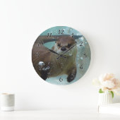A cute Brown otter swimming in a clear blue pool Große Wanduhr (Zuhause)