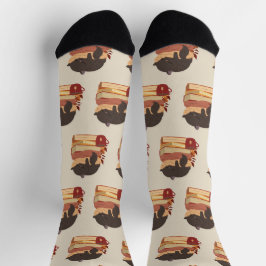 A cute kitten sleeping curled up on a pile of book socken