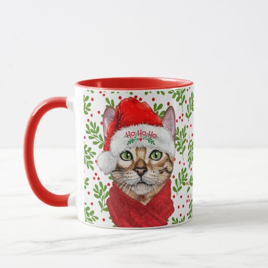 Abessinienkatze in einer Weihnachtsmannmütze mit H Tasse (Links)