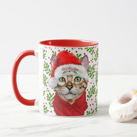 Abessinienkatze in einer Weihnachtsmannmütze mit H Tasse (Mit Donut)