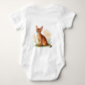 Abessinische Katze umgeben von sanften Farben und Baby Strampler (Rückseite)