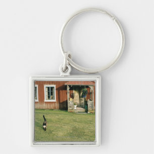 Abgenutztes rotes Haus mit einer Katze auf dem Schlüsselanhänger