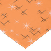 Abstrakte Linien und rosa Sterne auf orange Retro Tischdecke (Schrägansicht)