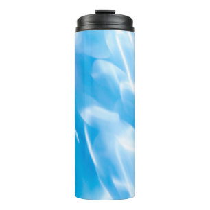 Abstrakter Glitzer leuchtet auf blauem Hintergrund Thermosbecher