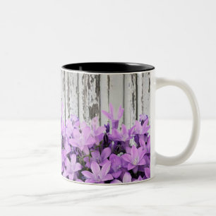 Abstraktes lila Lilys auf hölzernem Zaun Zweifarbige Tasse