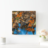 Abweichenmonarchschmetterlinge haften Blätter an Quadratische Wanduhr (Zuhause)