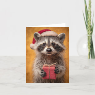 Adorable Raccoon in einer Weihnachtsmannmütze, die Feiertagskarte