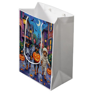 Affenpinscher-Hunde beim Trick-or-Treat an Hallowe Mittlere Geschenktüte