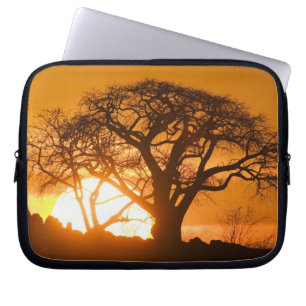 Afrika, Botsuana, Untergehende Sonne silhouettiert Laptopschutzhülle