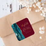 Agate Geode Script Aquamarin Gold Burgundy Wedding Quadratischer Aufkleber<br><div class="desc">Dieser elegante,  moderne Hochzeitsaufkleber besticht durch eine aquamarine blaue Aquarellfarbe in einem Geodedesign,  das mit Imitaten mit goldenem Glitzer bestickt wurde. Der goldfarbene Text auf bordeauxrotem Hintergrund lässt sich leicht anpassen,  wobei die Namen der Braut und des Bräutigams in handgeschriebener Kalligraphie über einen großen Ampersand verteilt sind.</div>