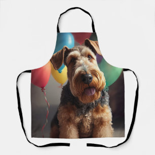 Airedale-Hund mit Kuchen und Luftballons Schürze