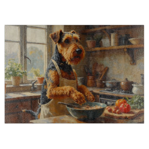 Airedale Terrier kocht in der Küche Schneidebrett