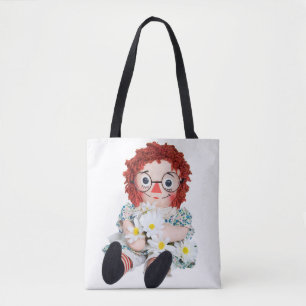 alte Lumpenpuppe mit Gänseblümchenstrauß Tasche