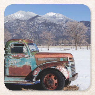 Alter LKW, der auf dem Gebiet sitzt Rechteckiger Pappuntersetzer