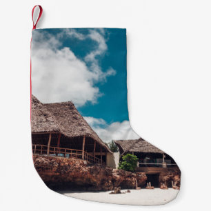 Alter tropischer Bungalow aus Holz am Strand. Kleiner Weihnachtsstrumpf