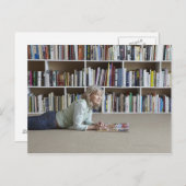 Ältere Frau, die in Bücherregalen liest Postkarte (Vorne/Hinten)
