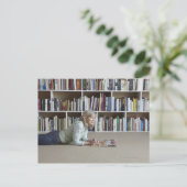 Ältere Frau, die in Bücherregalen liest Postkarte (Stehend Vorderseite)