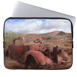 Altes Auto, das in der Wüsten-Landschaft verroste Laptopschutzhülle