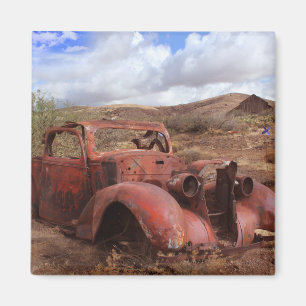 Altes Auto, das in der Wüsten-Landschaft verroste Magnet