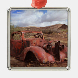 Altes Auto, das in der Wüsten-Landschaft verroste Silbernes Ornament