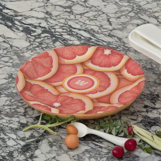 Anfänglich frisch gepicktes rosa Grapefruitmonogra Pappteller