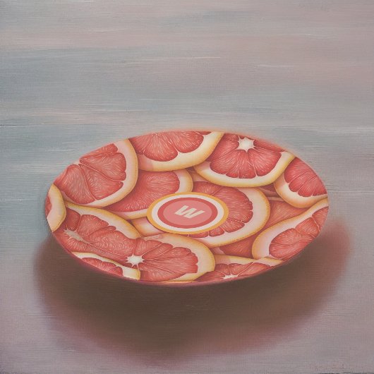 Anfänglich frisch gepicktes rosa Grapefruitmonogra Pappteller