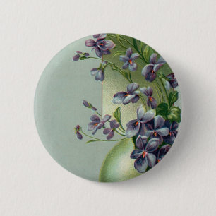 Antike blühende violette Blumen in einem Osterei Button