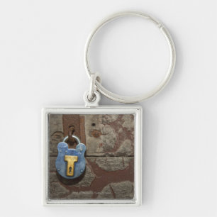 Antiker Metallverschluß auf Steinwand Schlüsselanhänger