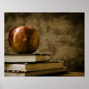 Apfel auf einem Bücherstapel auf einem Schreibtisc Poster