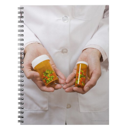 Apotheker, der die Tablettenflaschen hält Notizblock (Vorderseite)