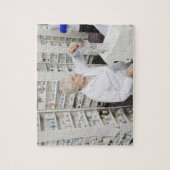 Apotheker gießt Tabletten in den Zähler Puzzle (Vertikal)