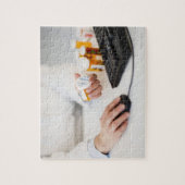 Apotheker mit Pillenflaschen am Computer Puzzle (Vertikal)
