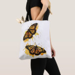 Artistic Watercolor Monarch Butterfly Nature Art Tasche<br><div class="desc">The design features two vibrant monarch butterflies in mid-flight, rendered with artistic paint splatters in warm shades of orange and yellow. This nature-inspired graphic captures the delicate elegance of spring wildlife. It makes a wonderful gift for gardeners, entomology enthusiasts, nature lovers, or anyone who appreciates the symbolism of freedom and...</div>
