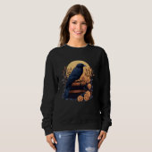 Ästhetischer gotischer Rabe sitzt auf einem Stapel Sweatshirt (Vorne ganz)