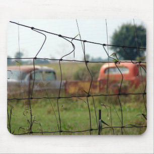 Autos und Lastwagen rosten auf einem ländlichen Fe Mousepad