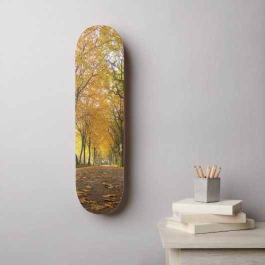 Autumn path with yellow trees and fallen leaves skateboard (Wandkunst)