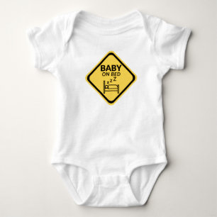Baby auf dem Bett lustiger Baby-Body Strampler
