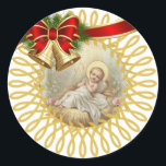 Baby Jesus Manger Christmas Bells Ribbon Runder Aufkleber<br><div class="desc">Wunderschönes Bild des Jesuskindes,  der in der Wache liegt. Weihnachtsglocken und -band betonen das Bild.</div>