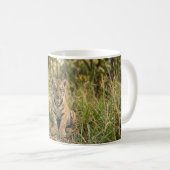Baby-Tiger sitzt in Gras Kaffeetasse (VorderseiteRechts)