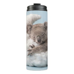 Babykoala schläft friedlich auf einem flauschigen thermosbecher