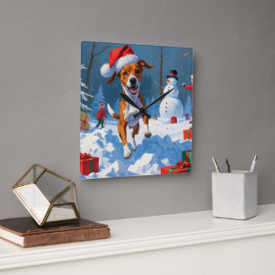Basenji-Hund spielt im Schnee Winterlandschaft Quadratische Wanduhr