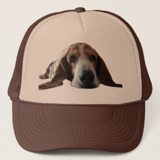Basset Hound, das sich hinlegt Truckerkappe