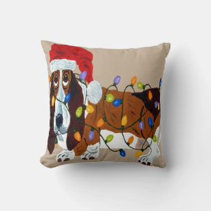 Basset in Weihnachtslichter verheddert Kissen