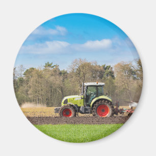 Bauer auf dem Traktor, der sandigen Boden im Magnet