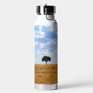 Baum auf einem geernteten Weizenfeld Trinkflasche
